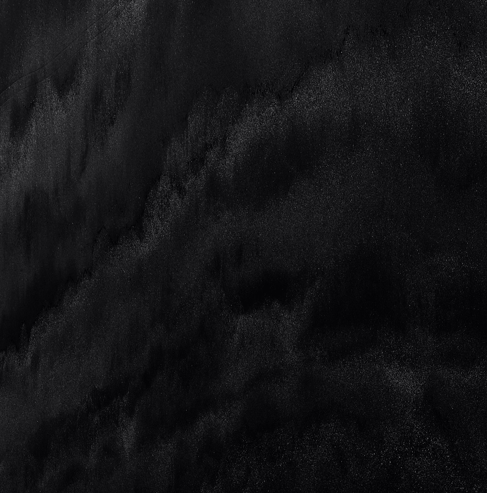 Abstract black textured background with soft gradients.