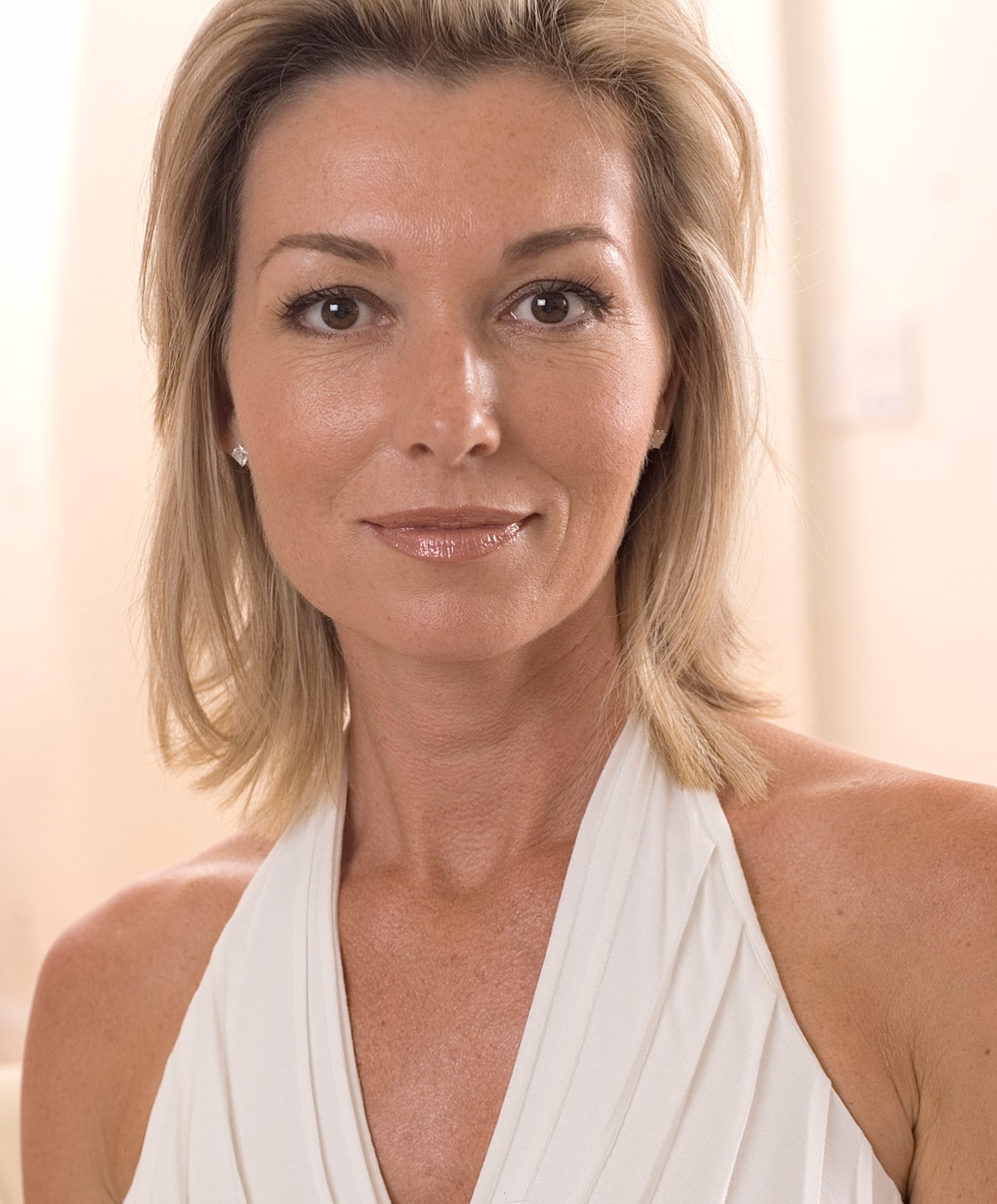 Woman with short blonde hair and light makeup.