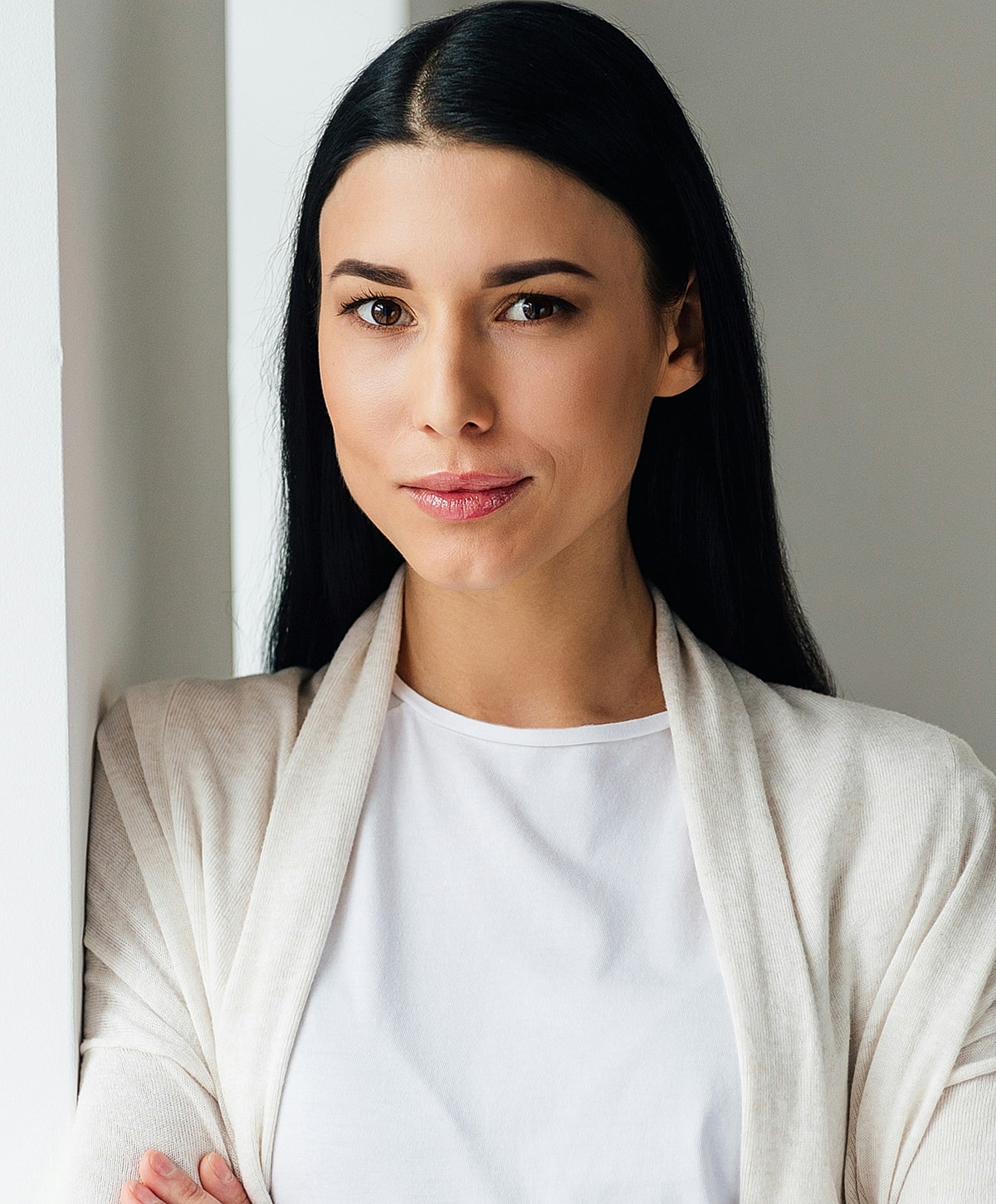 Fayetteville Brow Lift model with long hair, neutral expression, stylish attire.