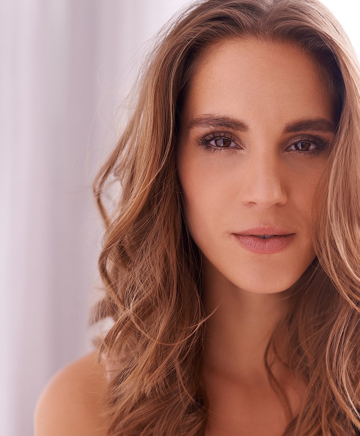 Close-up portrait of a woman with wavy hair.
