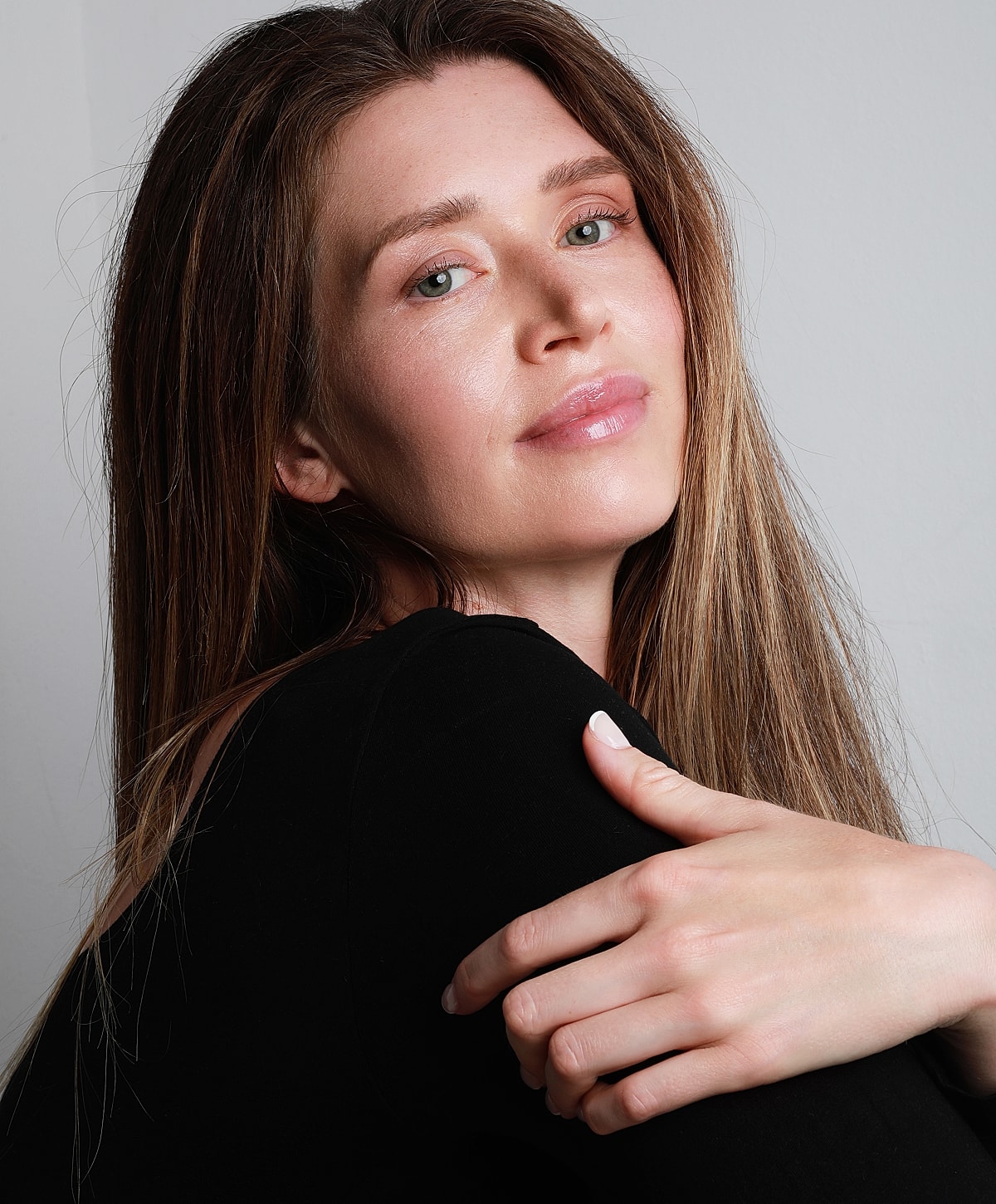 Woman with long hair and natural makeup smiling.