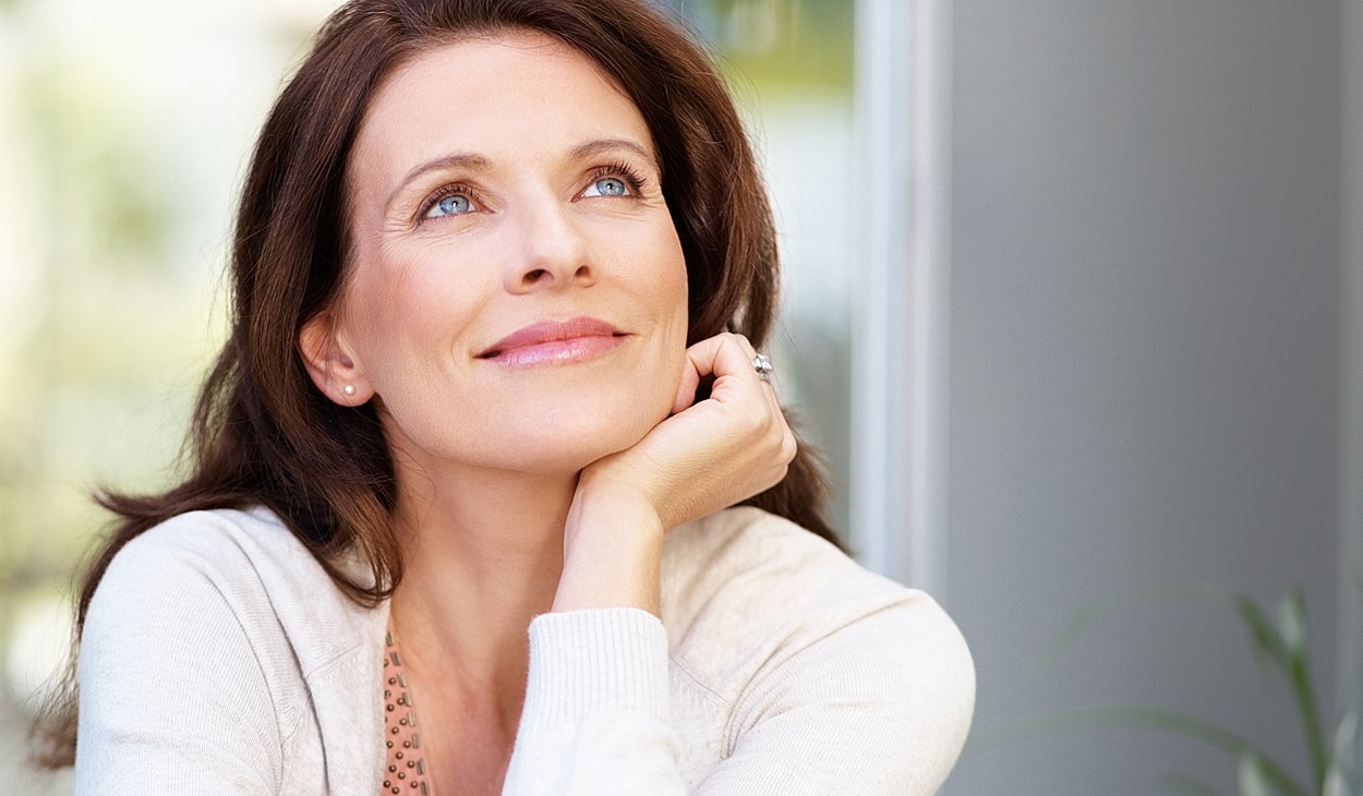 Woman looking thoughtfully with a serene expression.