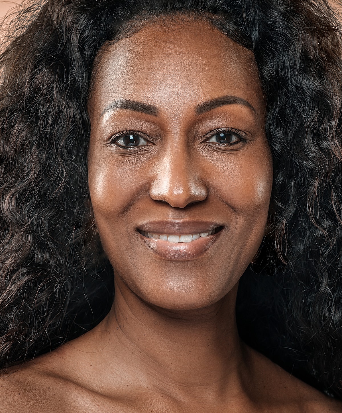 Fayetteville Microneedling model with curly hair and clear skin.