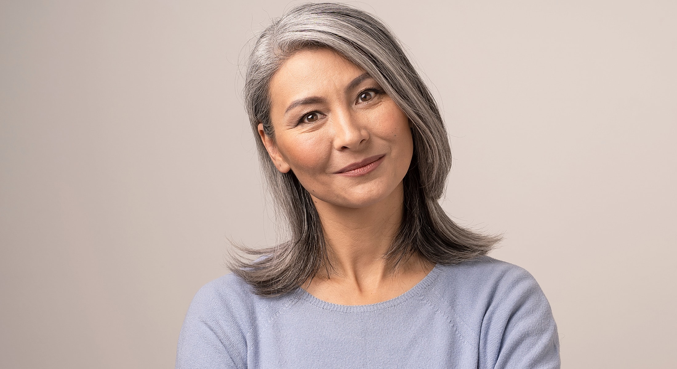 Fayetteville Blepharoplasty model with gray hair wearing light sweater.