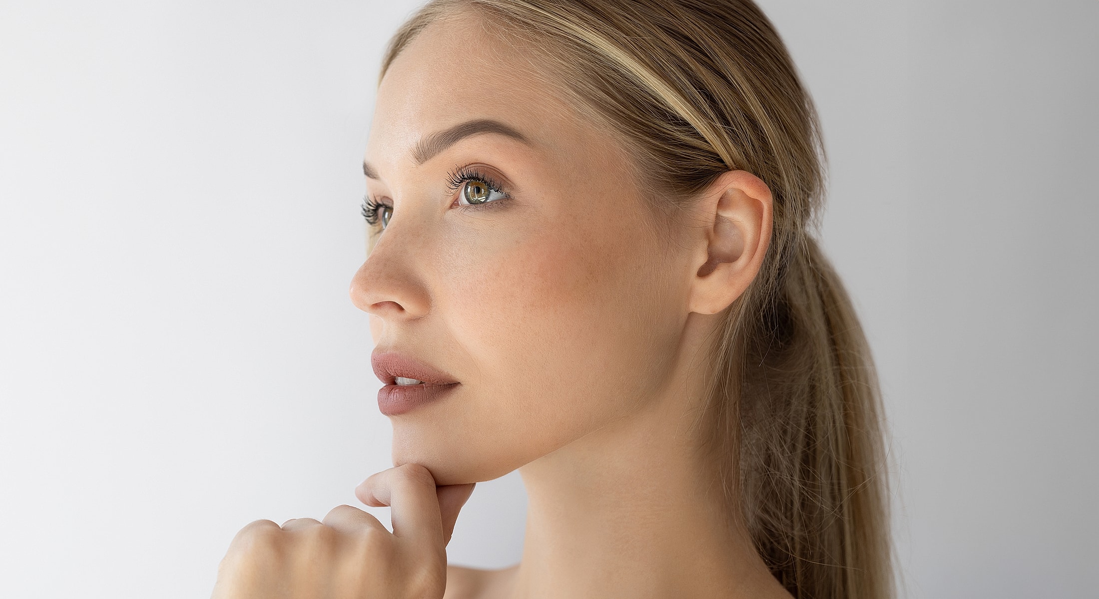 Profile of a thoughtful woman against a white background.