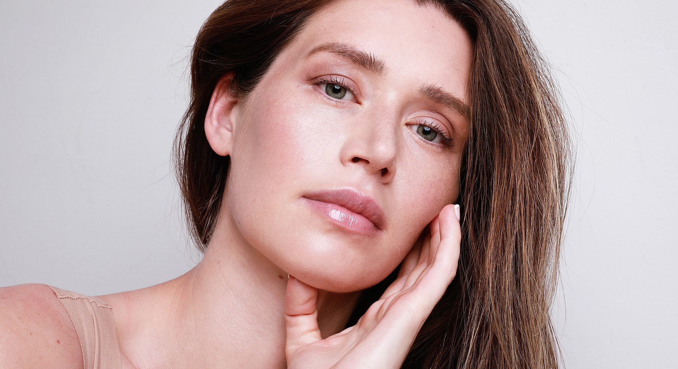 Fayetteville Microneedling model touching her face.